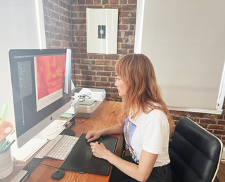 Artist Akiko Stehrenberger in front of a computer designing her Dune Part Two poster.
