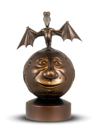 Bronze sculpture of a face with a bat on top against a white background